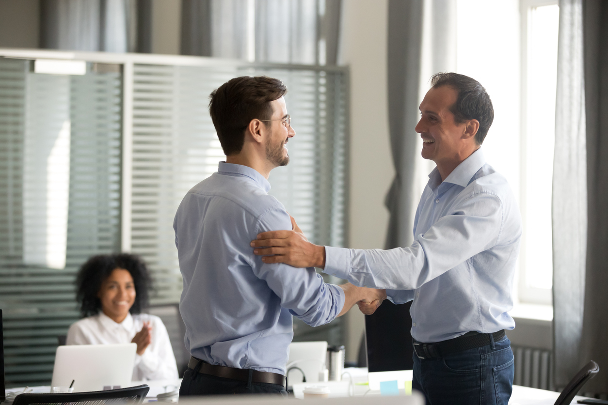 Smiling business professionals support each other during meeting.